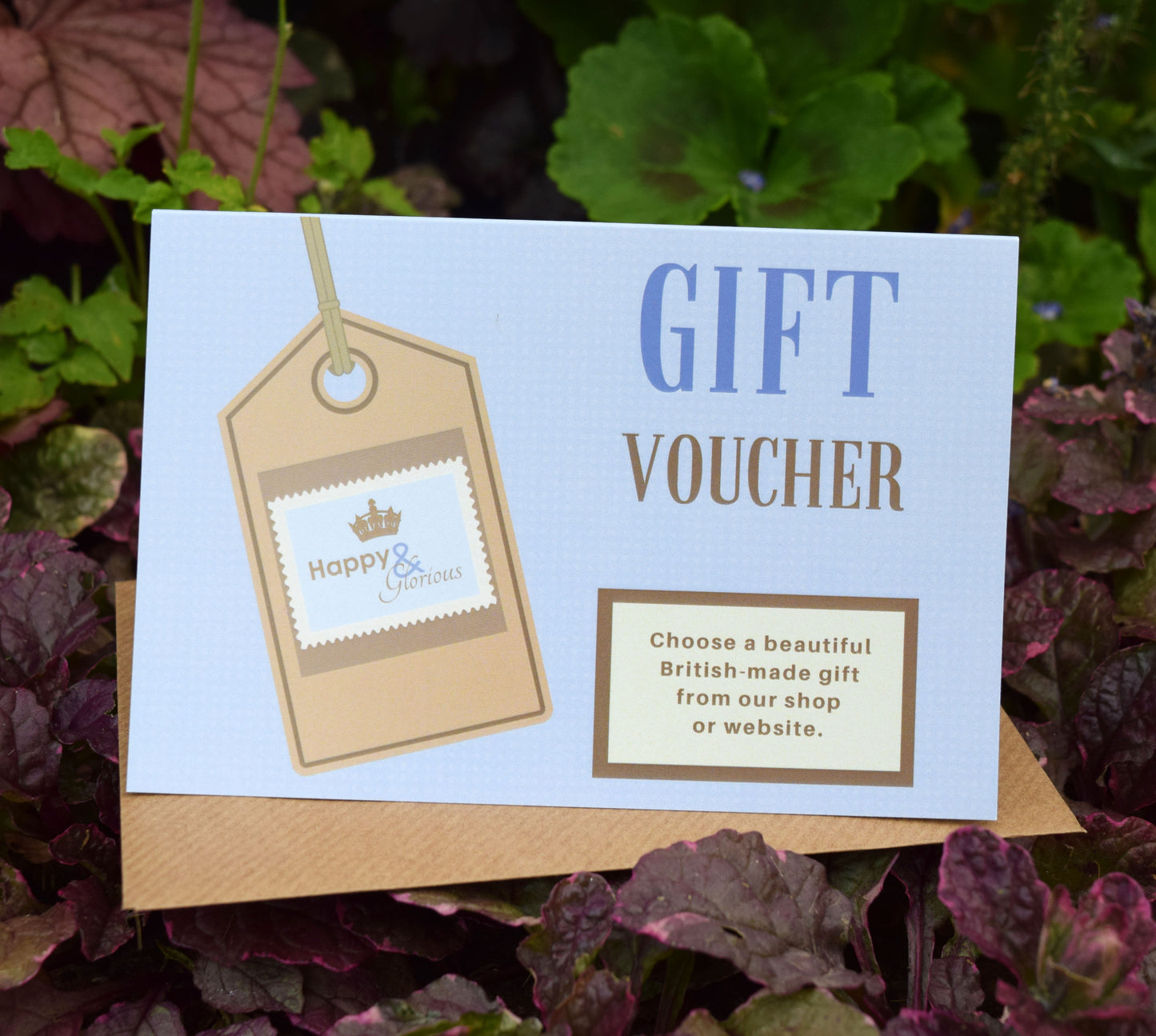 A paper gift voucher with a blue background and a beige tag, displaying the text 'GIFT VOUCHER' and the brand name 'Happy & Glorious'.