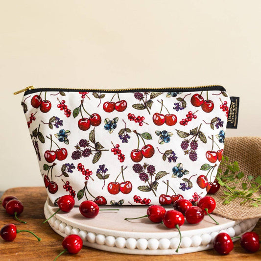 Pouch with cherry pattern on a wooden surface with cherries around